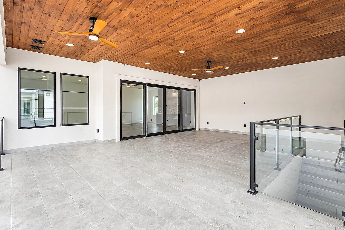 Covered terrace with wood ceiling and glass rail